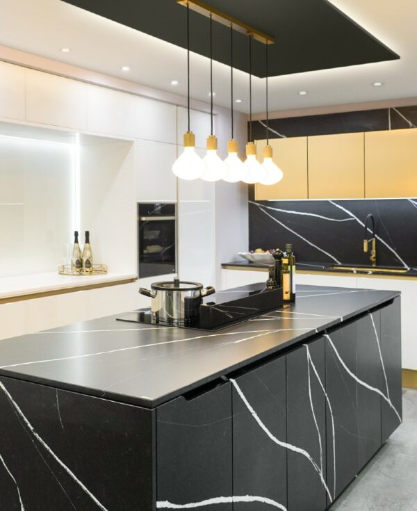 gold lanesborough multi-pendant light suspended above an induction hob an a black and white marble kitchen island