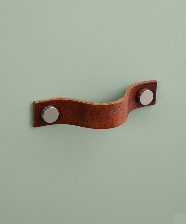 large dark tan Thor leather handle with silver knobs against green background