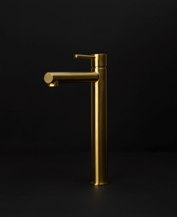 gold inga mixer tap against black background