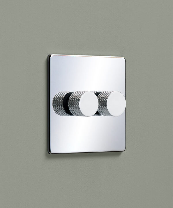 polished chrome double dimmer switch with 2 white knurled knob dimmers on a pale sage green painted wall