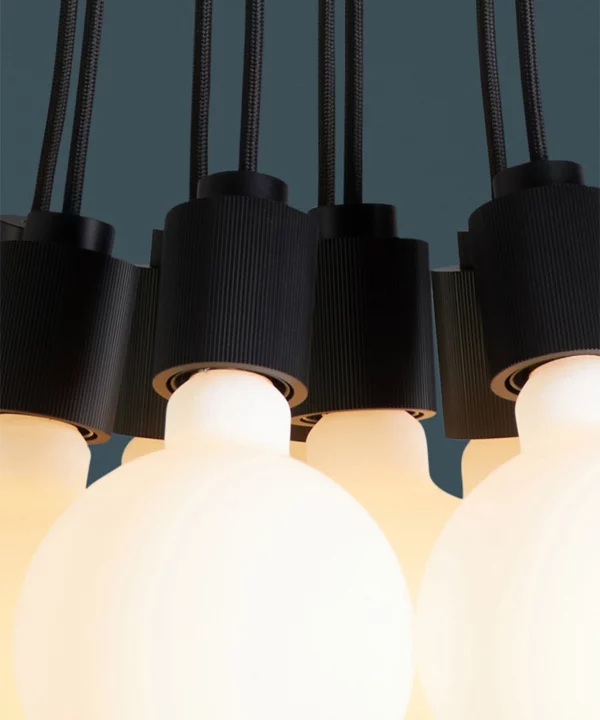 closeup of black athenee statement pendant light against blue background
