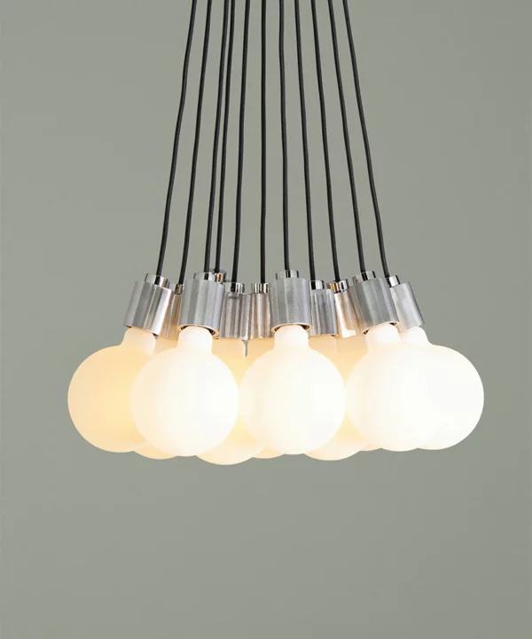front on shot of chrome athenee statement pendant light against green background
