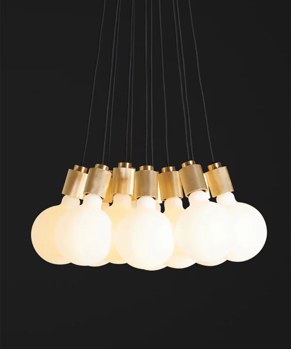 closeup of front of gold athenee statement pendant light against black background