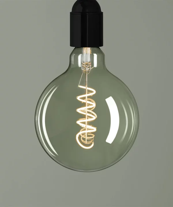 smoked light bulb with spiral filament against green background