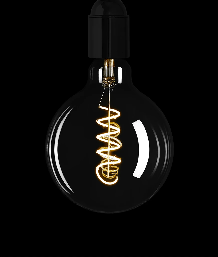 smoked light bulb with spiral filament against black background