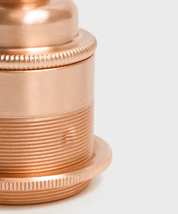 closeup of copper light bulb holder against white background