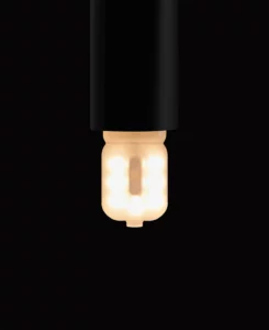 G9 LED bulb in a black bulb holder against a black background