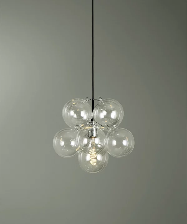small clear glass bubble pendant light with 8 glass orbs against green background
