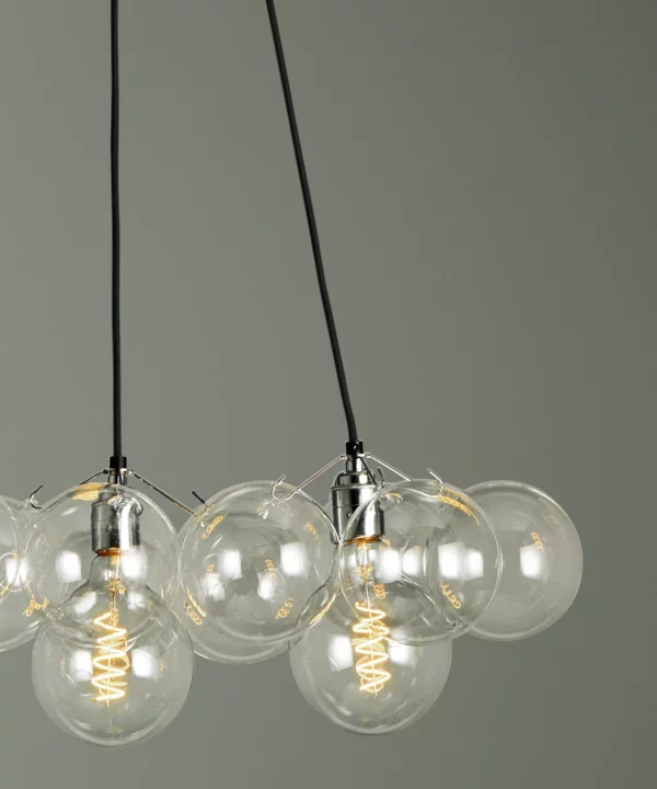 closeup shot of medium clear bubble chandelier light with 12 bubbles against green background