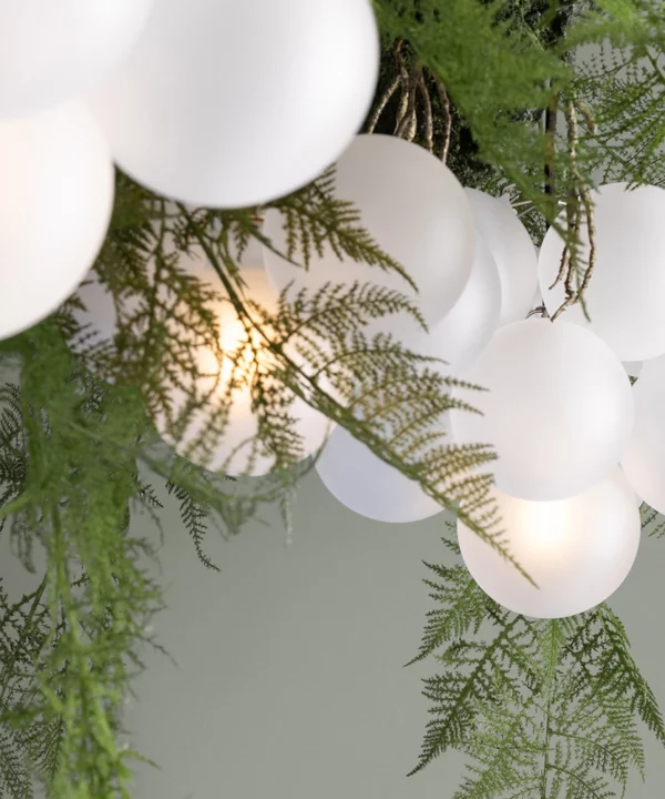 close up shot of fern lighting - bubble chandelier bulbs with faux fern fronds
