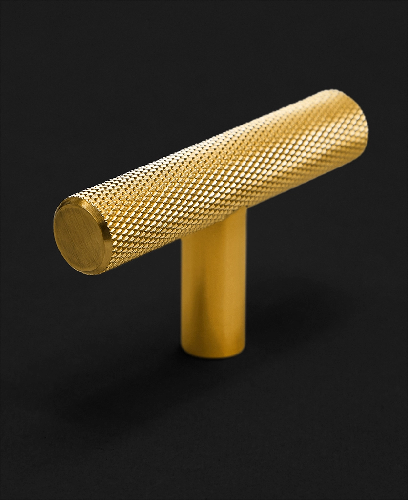 gold knurled t-bar pull handle on a black background