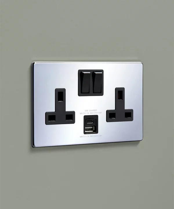 chrome double socket with usb and usbc charging ports on a sage green wall