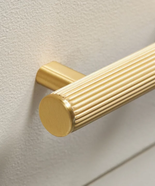 gold ribbed chunky handle on a cream modern kitchen unit