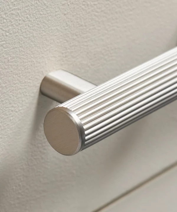 dull silver ribbed kitchen cupboard handle on a cool neutral drawer
