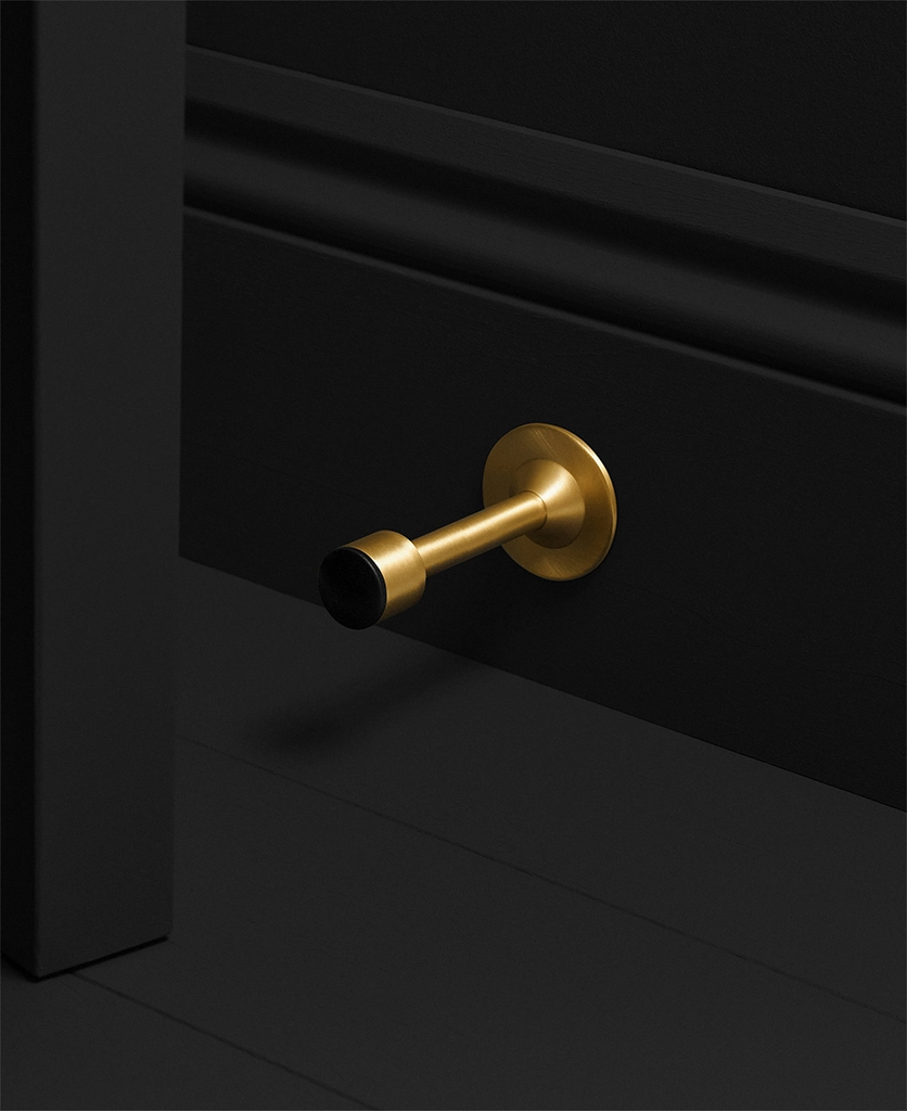 gold door stop fixed to a skirting board