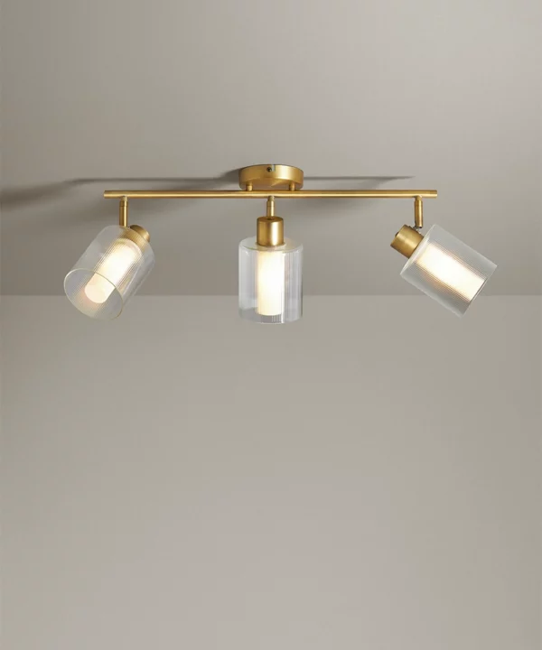 gold ceiling light in 3 bar spotlight style on a neutral background