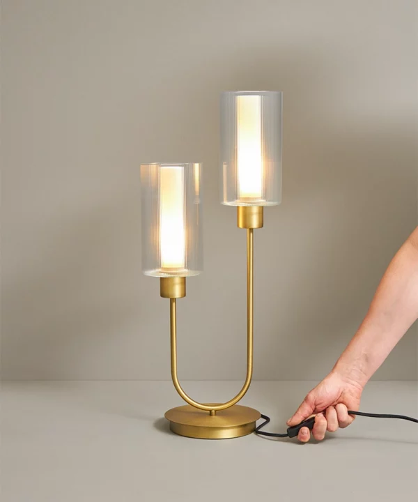 gold table lamp with two bulbs in ribbed glass shades