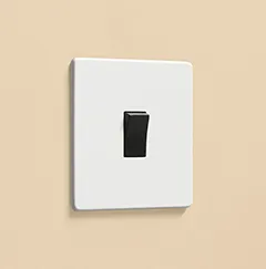 white rocker light switch with black rocker on a warm yellow wall