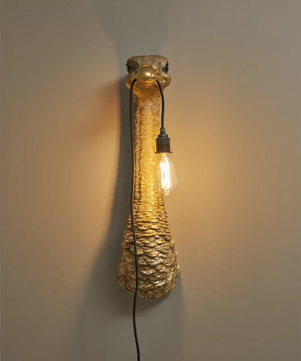 gold ostrich plug-in wall light on a neutral wall