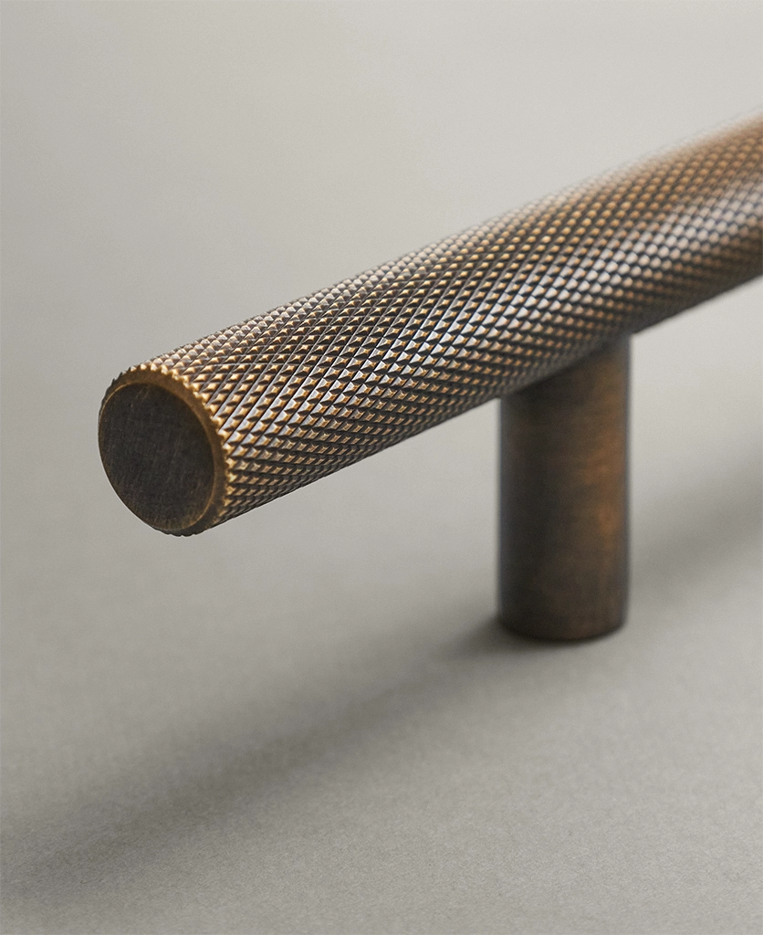 antique brass knurled pull handle on a neutral background