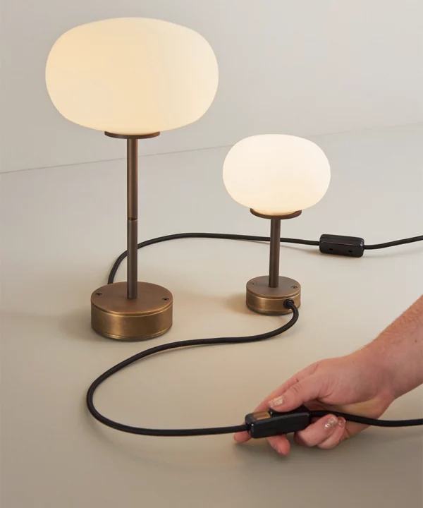 two table lamps side by side with antique brass base and stem with opaque glass shade