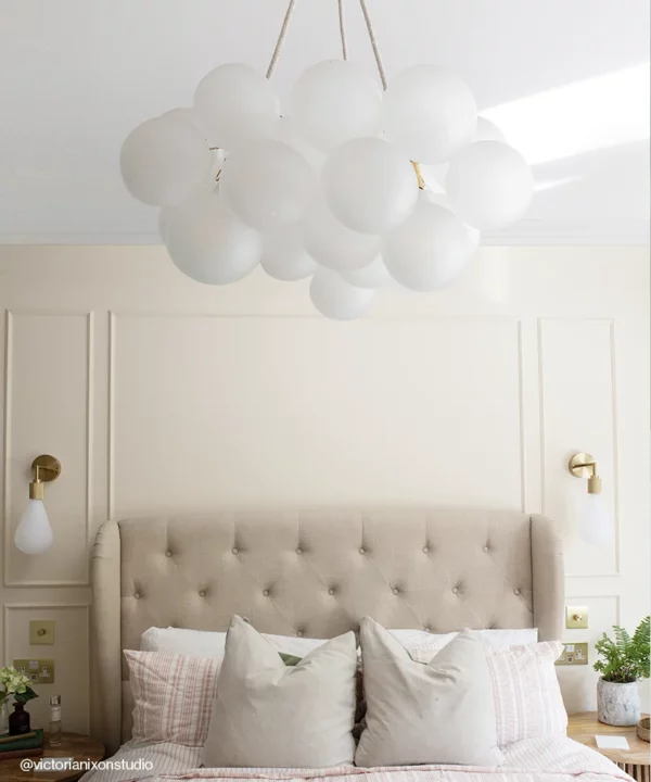Medium bubble chandelier light above a bed with linen cables