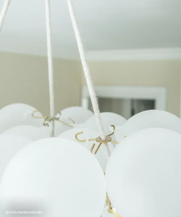 Close up of a bubble chandelier showing gold hooks and linen fabric cables