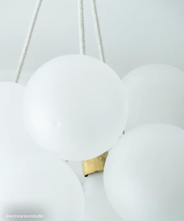 Extreme close up of bubble chandelier light frosted baubles with gold bulb holders and linen fabric cables