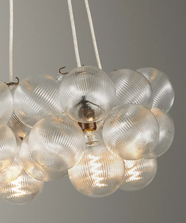 close up shot of a Dowsing & Reynolds fluted bubble chandelier with linen fabric cable and antique brass hardware