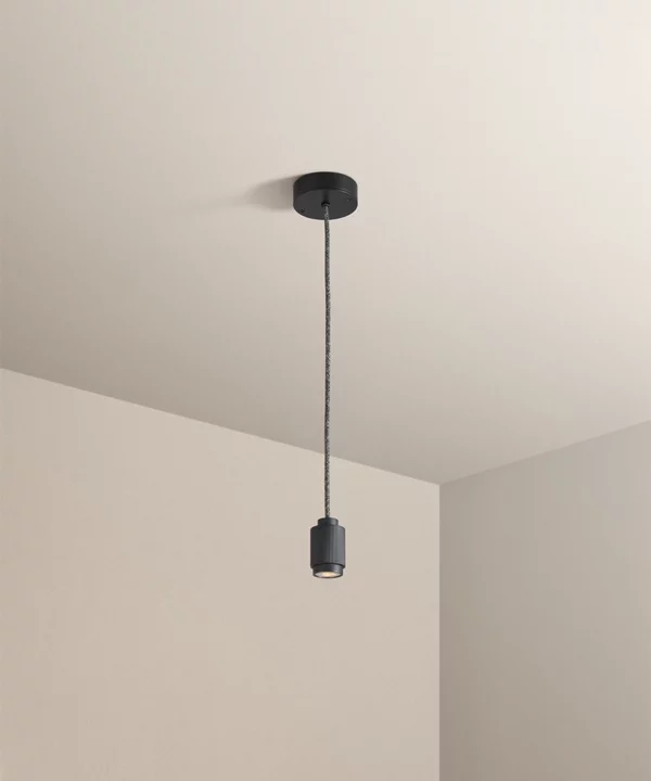 industrial style black spotlight pendant hanging from a taupe ceiling