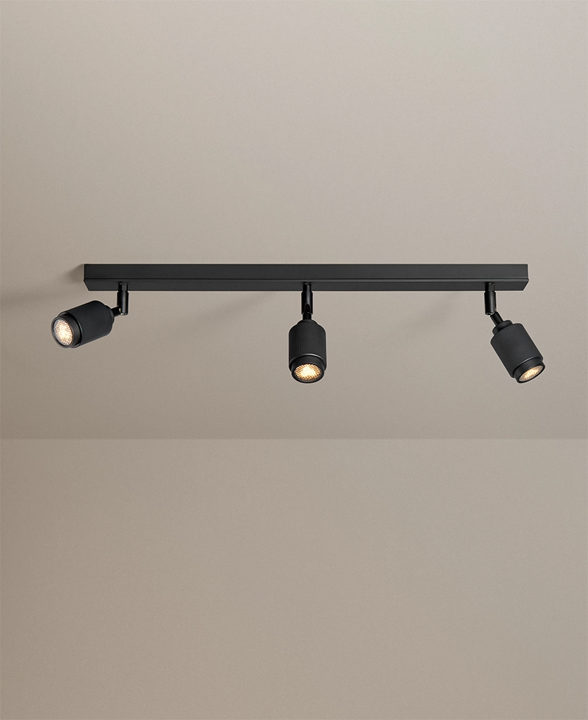 modern ceiling spotlights in black with three lights shot on a grey neutral background