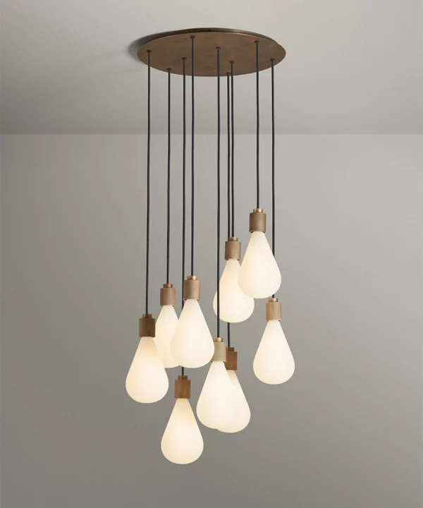 extra large cascading pendant light with nine lights with opaque teardrop bulbs featuring antique brass hardware and black fabric cables