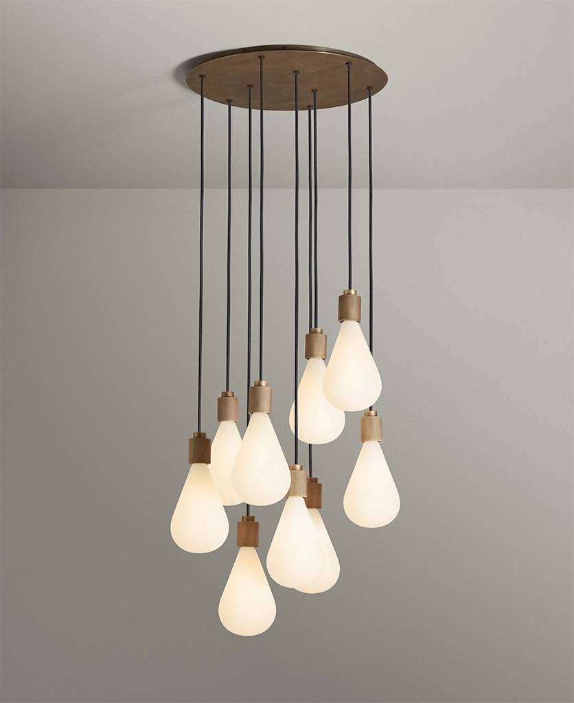 extra large cascading pendant light with nine lights with opaque teardrop bulbs featuring antique brass hardware and black fabric cables